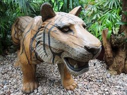 wooden tiger on pebbles