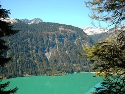 panoramic view of a lake with turquoise water in the mountains of Switzerland