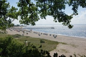 lot of cabins and long pier on beach of baltic sea
