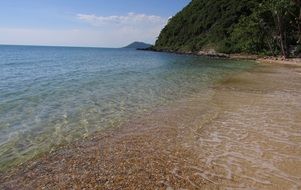 landscape of clear ocean water near the mountain