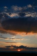 red rays of the sun in the sunset on the clouds