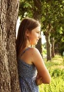 girl in summer dress near a tree