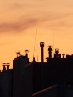 chimneys silhouettes at sunset sky