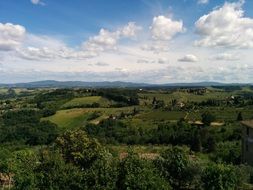 scenic green countryside beneath fluffy clouds, italy, chianti