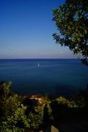 distant view of a boat in the blue sea