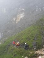 tourists on a mountain trail into the fog