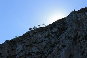 sun behind the rock