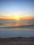 sunset on the horizon of calm water at sea