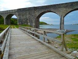 wooden bridge on the background of the arched bridge