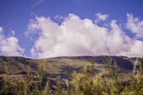 white clouds over the hill