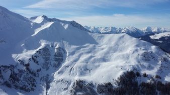 mountains in the snow under the sky with clouds