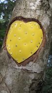 yellow metal heart on wood