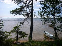 rowing boat on the shore of a large lake