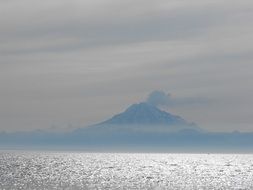 distant view of a mountain in fog on the coast of alaska