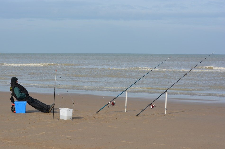 landscape of fishing rods and fisher by the sea