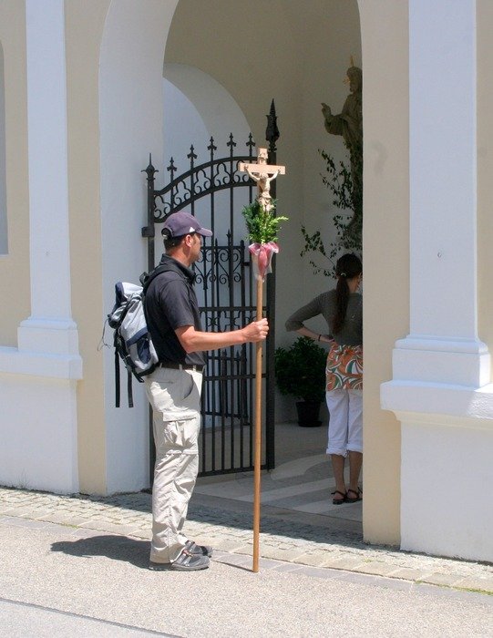 pilgrim with cross at church gate