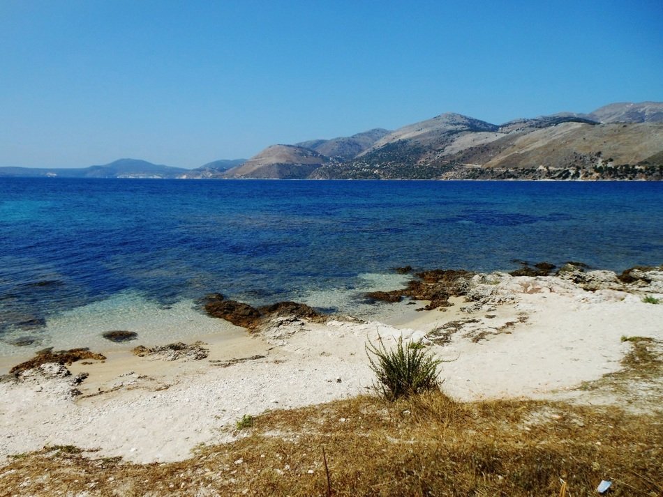 blue sea and white sand on a background of mountains