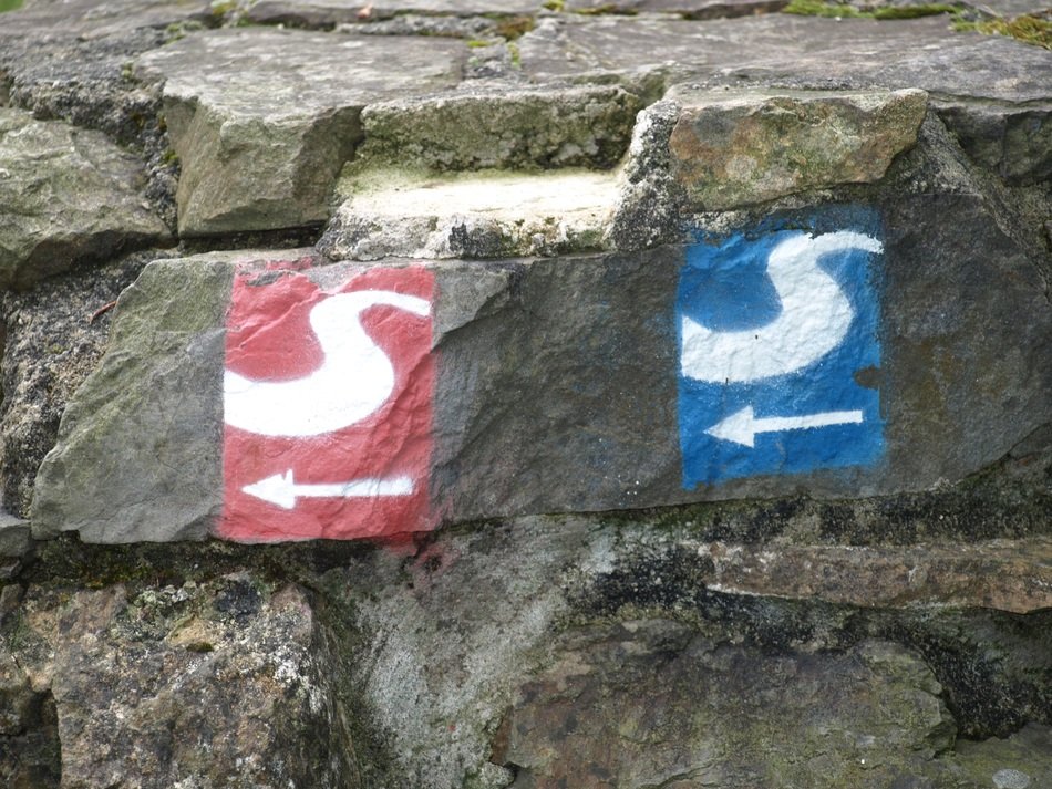Red-white and blue-white signs on an adventure trail in Sieg Valley