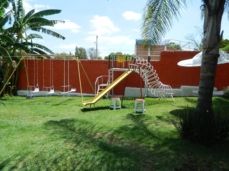 Colorful children's playground among the plants in the courtyard