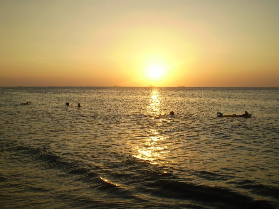 swining people at sunset, seascape
