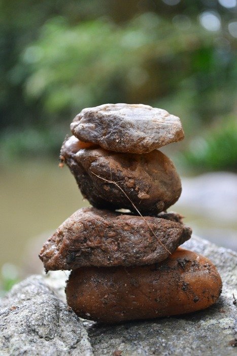 macro view of stack of stones on a rock on river