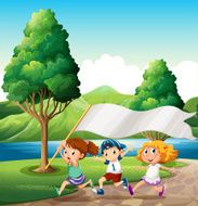 Kids running near the riverbank while bringing an empty banner