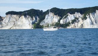 white cliffs on the Mon island and white boat on the water