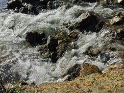 foamed water streaming among rocks