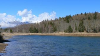 Landscape with the pond and mountains in spring