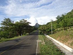 free asphalt road to distant mountain in summer landscape