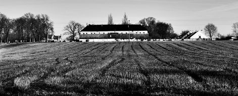 farm buildings at harvested field, black and white