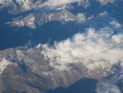 view of the Alpine mountains from the window of the plane
