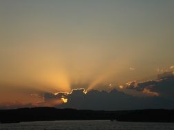 the sun has gone beyond the clouds on the horizon