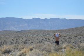 person stays in desert looking at mountains, usa, california