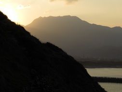 mountain silhouettes during sea sunset