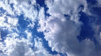 white clouds with sun rays in the blue sky