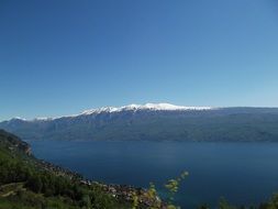 sunlight on snow capped mountain at water