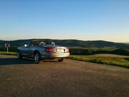 mazda cabriolet on road at dusk