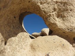 blu sky through hole in rock