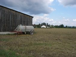 wheel cystern at barn in farm landscape