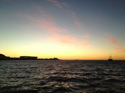 distant view of a ship at sunset in the ocean