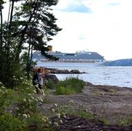 couple resting on coast and cruise ship in oslofjord, norway, oslo