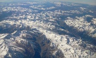 view from the plane to the alpine mountains