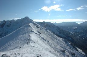 Snow-capped peaks of mountains in the glare of the sun