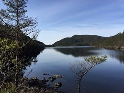 A scenic landscape by the lake against a clear sky background