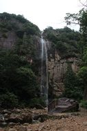 distant view of a small waterfall in the forestry alps