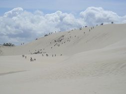 white clouds over sand dunes