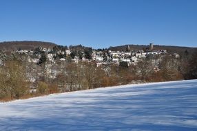 village on hillside above river at winter, germany, altweilnau