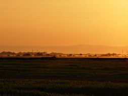 yellow sky over a field at sunset