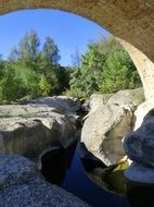 bridge arc above rocks and still water